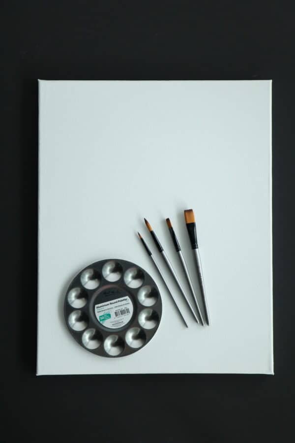 art supplies: aluminium palette, set of four brushes laying on 40 x 50cm canvas.
