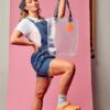 Model proudly holding up PVC&C Tote Bag by Cork & Chroma with neon orange keychain