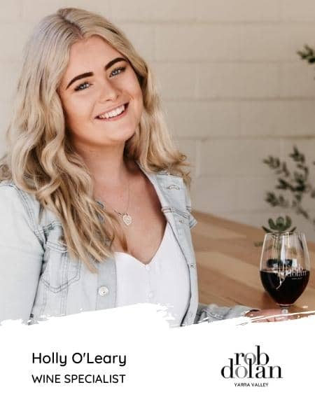 Holly O'Leary Wine Specialist at Rob Dolan Wines sitting with a glass of red wine